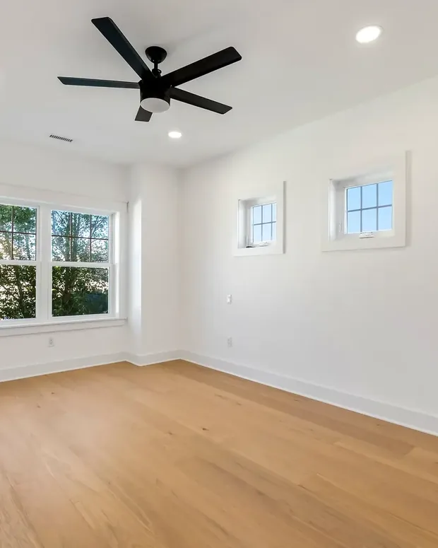 Empty living room as photographed for a listing, with bare walls and no furniture